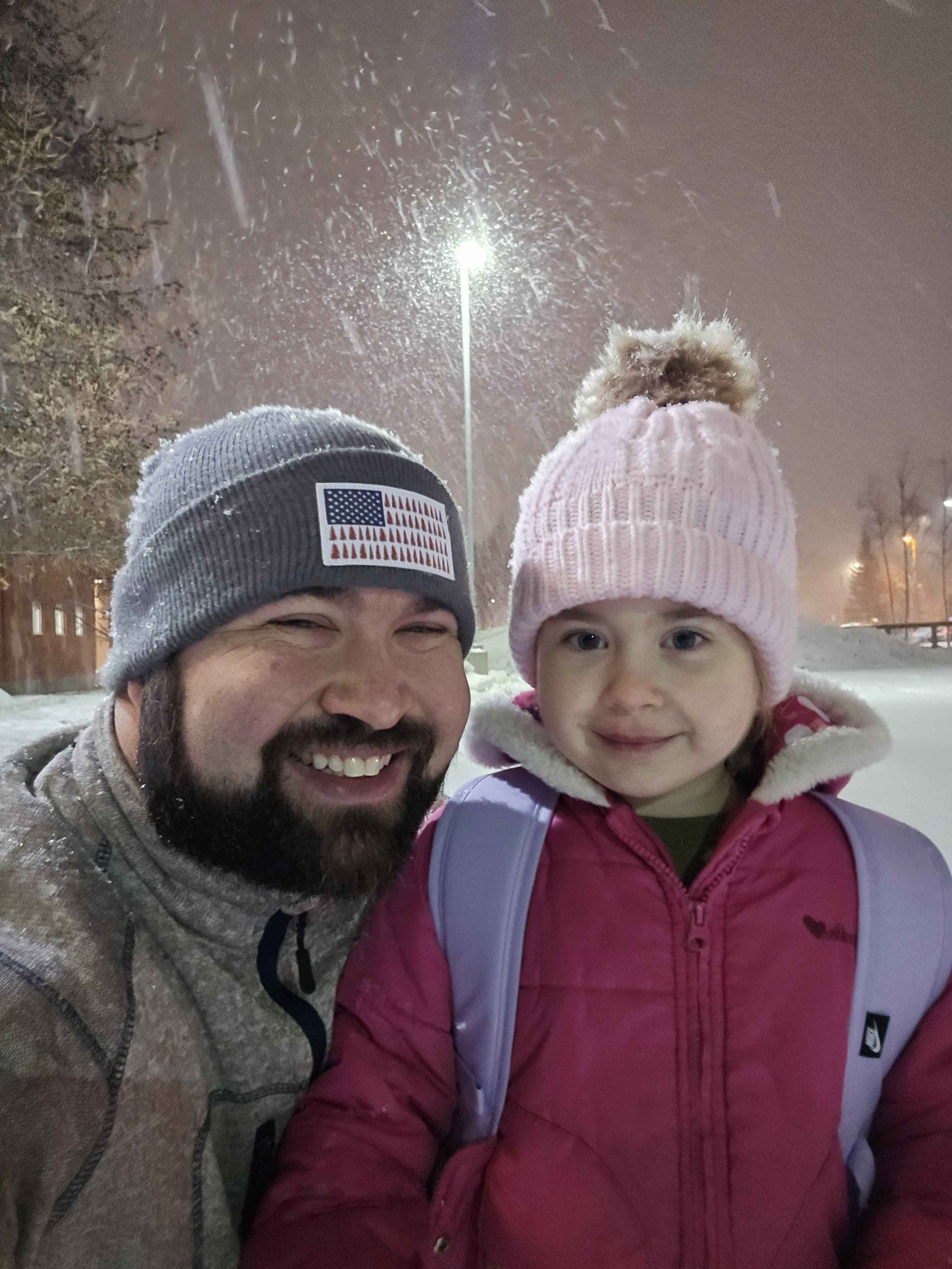 Jared with his daughter outside on a snowy evening